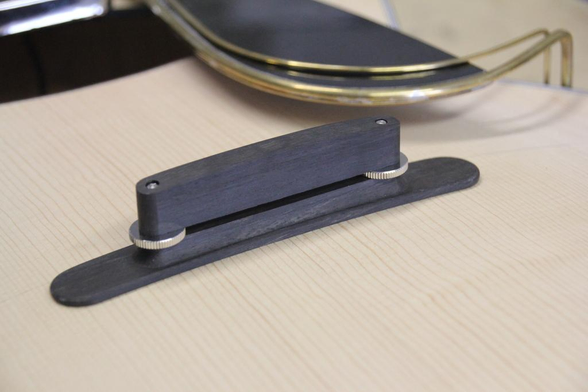 The ebony bridge of an archtop guitar.