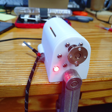 A printed enclosure that looks a bit like american mailboxes (those sitting on wooden posts) held down by a table clamp. The pin pushing the power switch can be pulled with a string (or as for demonstration a shoe lace). The machine has an indicator LED, as it's sound and motion wasn't good enough … lol. The geared motor has a flat flange attached to which up to 4 thin wires can be fixed to twist them.