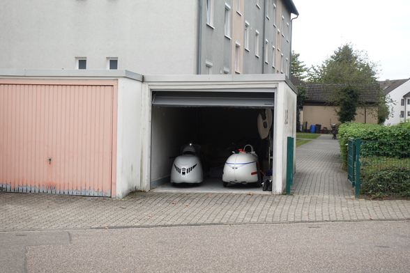 Navigation light "PosLi-P" on my Alpha velomobile in the garage, photo taken from across the street. Strada velomobile on the right side will get an adapted "XT" version of PosLi-P.